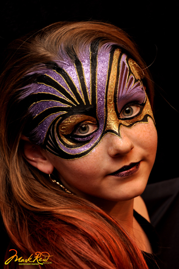 girl in face painting that is blue and gold on the top portion of her face